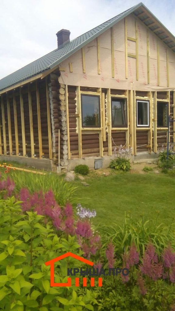 Старое бревенчатое строение с новой обрешёткой фасада и проёмами под окна