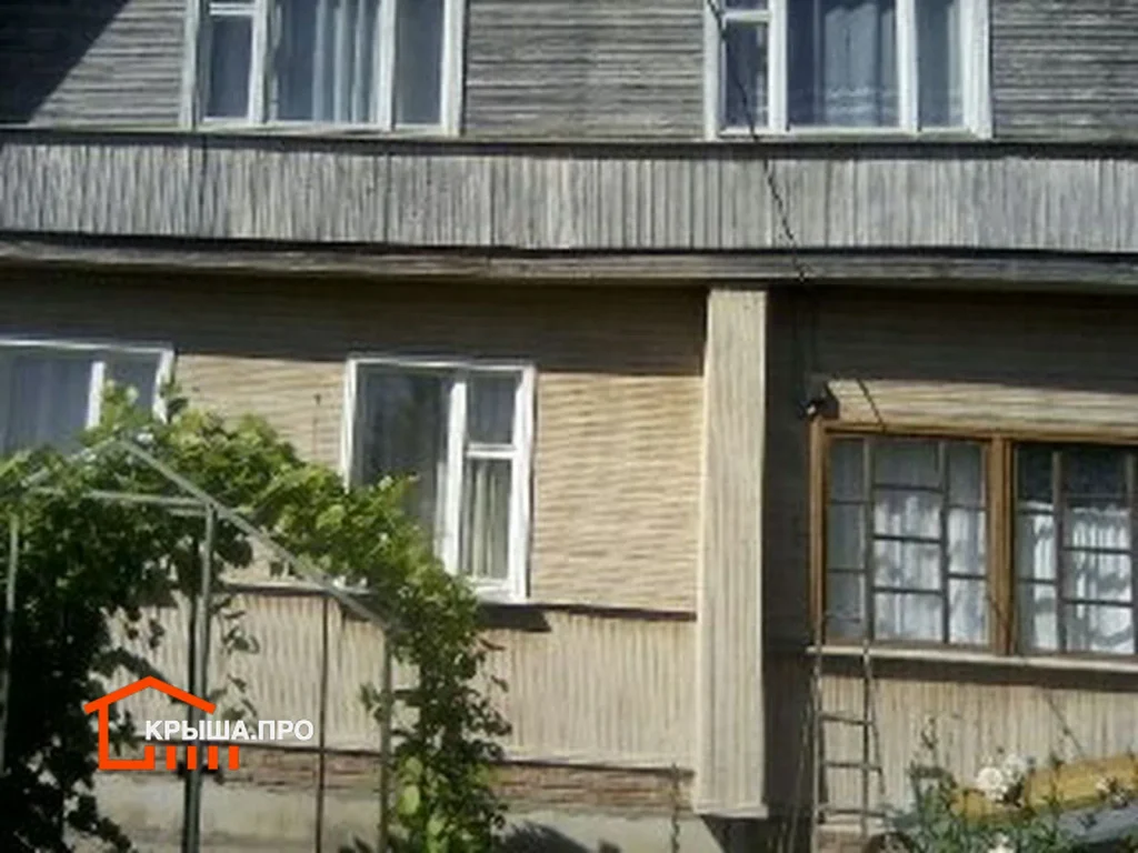 Фрагмент стены дома из бруса до обшивки сайдингом с выступающим поясом между этажами