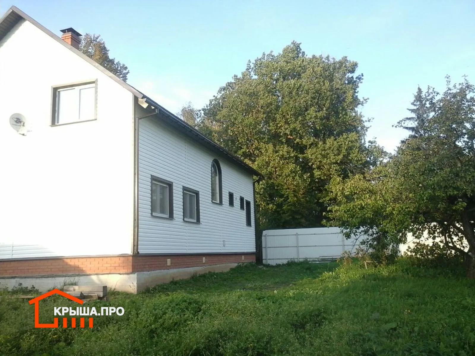 Отделка фасада сайдингом Döcke в селе Раменье: 225 м² за полторы недели — объект №17 - Фото 6 Частный дом в селе Раменье, обшитый белым виниловым сайдингом, вид с угла участка