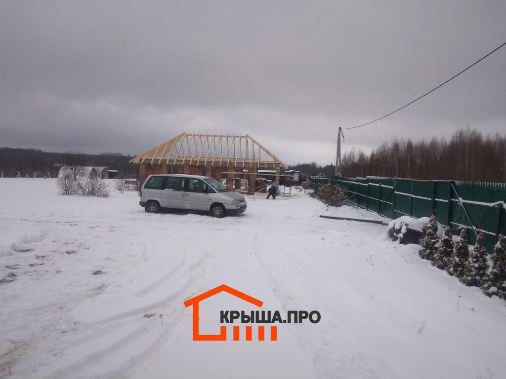 Стропильная система вальмовой крыши на кирпичных столбах в поле зимой