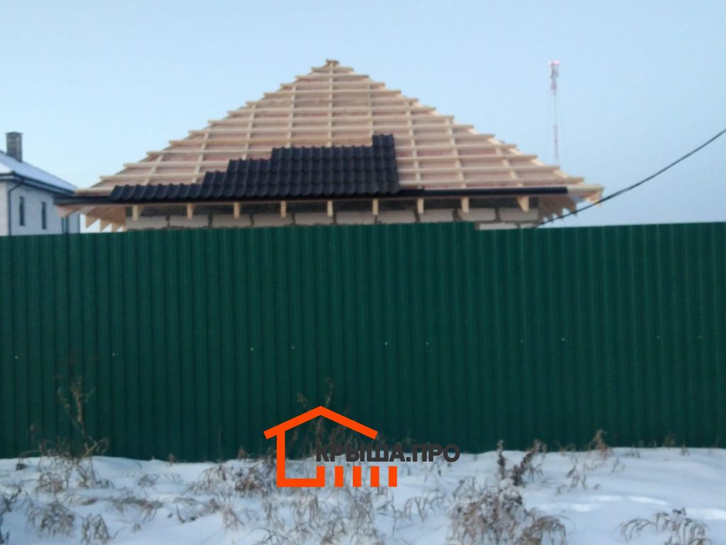 Первые ряды черепицы Braas уложены на обрешётку вальмовой крыши зимой