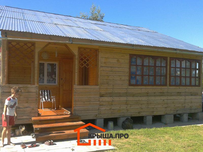 Веранда деревянного дома со старой кровлей из оцинкованного профлиста