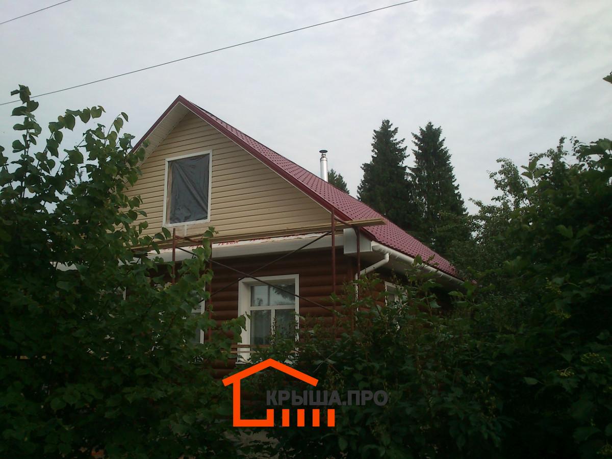Фронтон дома, обшитый сайдингом, подшитые софитом свесы и водосток по карнизу