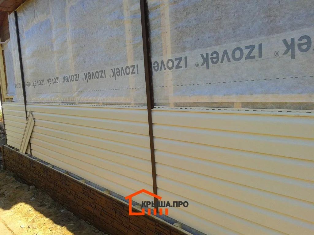 Отделка дачного дома сайдингом Holzplast в СНТ «Руза»: 195 м² за две недели — объект №8 - Фото 4 Ветрозащитная мембрана Izovek на стене и первые ряды винилового сайдинга над цокольными панелями