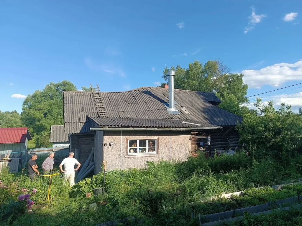 Частный дом с шиферной крышей из листов разного оттенка